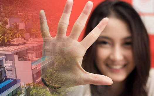 Smiling woman showcasing five essential tips for buying property in Phuket with luxury villas in the background.