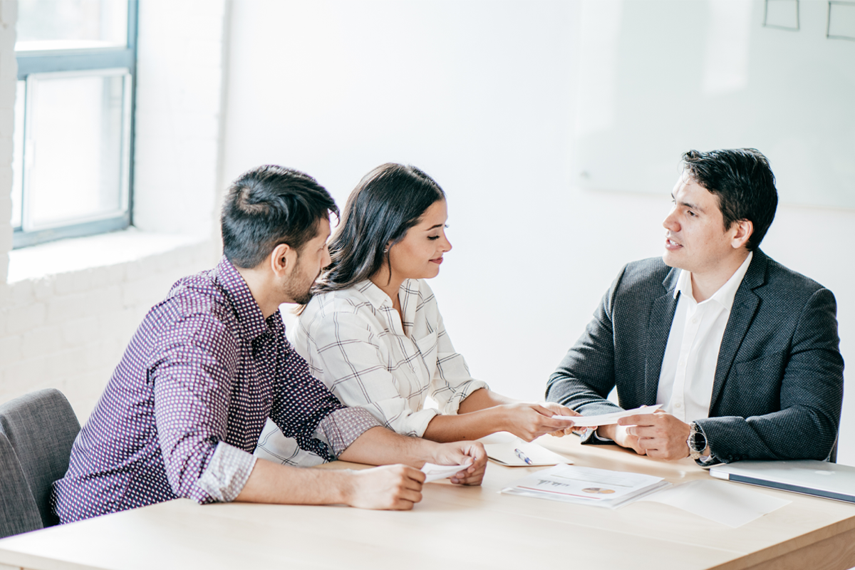 A group of professionals - a lawyer, an accountant, and a real estate agent - sitting at a table and discussing a property portfolio